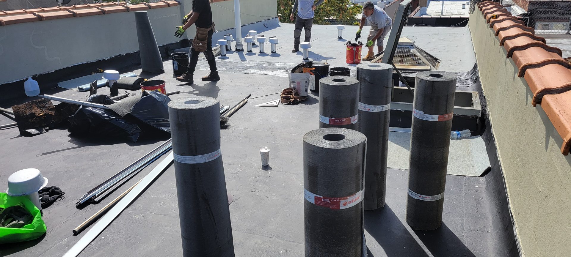 Roofing crew replacing a building's roof membrane